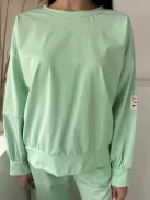 Rugalmas anyagú melegítőszett. Lenge, elöl rövid, hátul hosszú felső, magas, gumis derekú, megkötős nadrággal. (S-XL méretre ajánljuk.)
