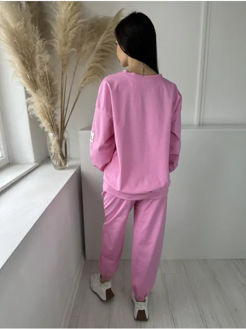 Rugalmas anyagú melegítőszett. Lenge, elöl rövid, hátul hosszú felső, magas, gumis derekú, megkötős nadrággal. (S-XL méretre ajánljuk.)