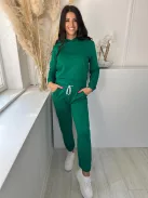 Rugalmas anyagú melegítő szett. Zsebes, kapucnis, rövid derekú felsőrész, gumis, magas derekú, zsebes nadrággal. A Modell S/M méretet visel. (S/M és L/XL méretekben.)