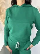 Rugalmas anyagú melegítő szett. Zsebes, kapucnis, rövid derekú felsőrész, gumis, magas derekú, zsebes nadrággal. A Modell S/M méretet visel. (S/M és L/XL méretekben.)