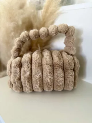   Pihe-puha szőrmés, cipzáras kistáska hosszúpánttal. Szélesség: 23,5 cm Magasság: 13 cm.
