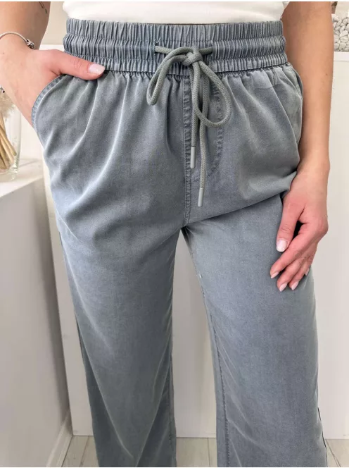 Lenge fazonú, egyenes szárú, magas gumis derekú, zsebes, megkötős nadrág. A Modell S/M méretet visel. (S/M és L/XL méretekben)