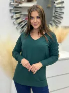 Rugalmas, puha anyagú, elöl rövid, hátul hosszú, vékony, kötött felső. A Modell L/XL méretet visel.