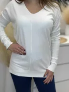 Rugalmas, puha anyagú, elöl rövid, hátul hosszú, vékony, kötött felső. A Modell L/XL méretet visel.