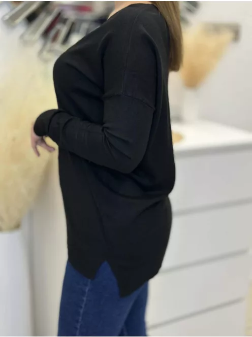 Rugalmas, puha anyagú, elöl rövid, hátul hosszú, vékony, kötött felső. A Modell L/XL méretet visel.